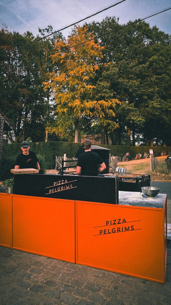 Pizza Pelgrims pizzastand met oranje panelen op een buitenevent