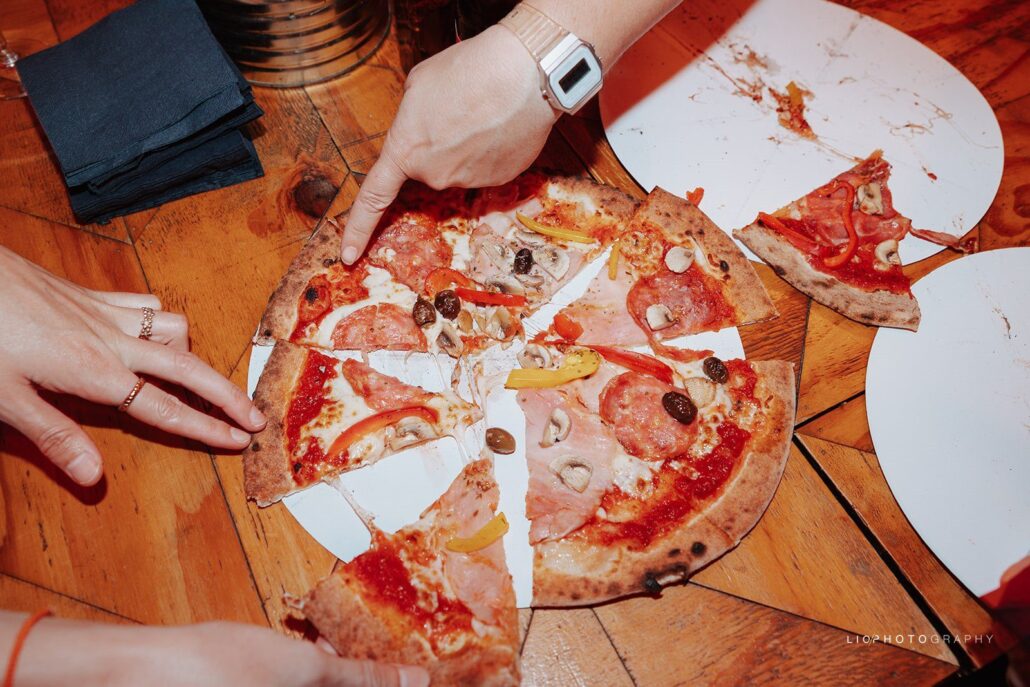 Gasten delen Napolitaanse pizza's aan tafel op een feest