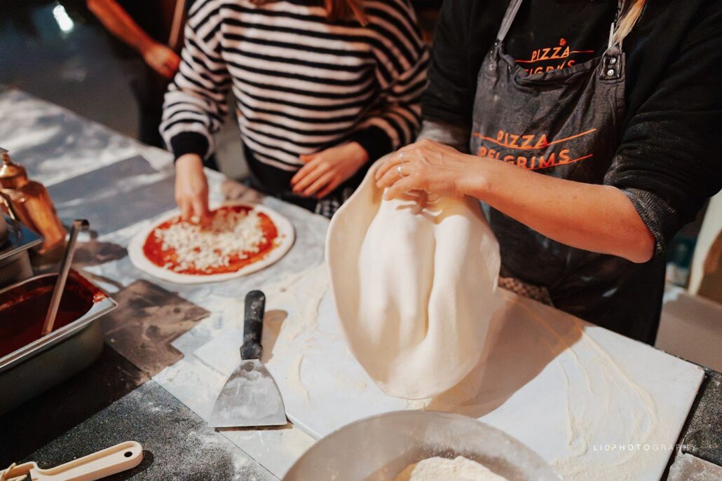 Pizzadeeg wordt met de hand uitgetrokken door het team van Pizza Pelgrims